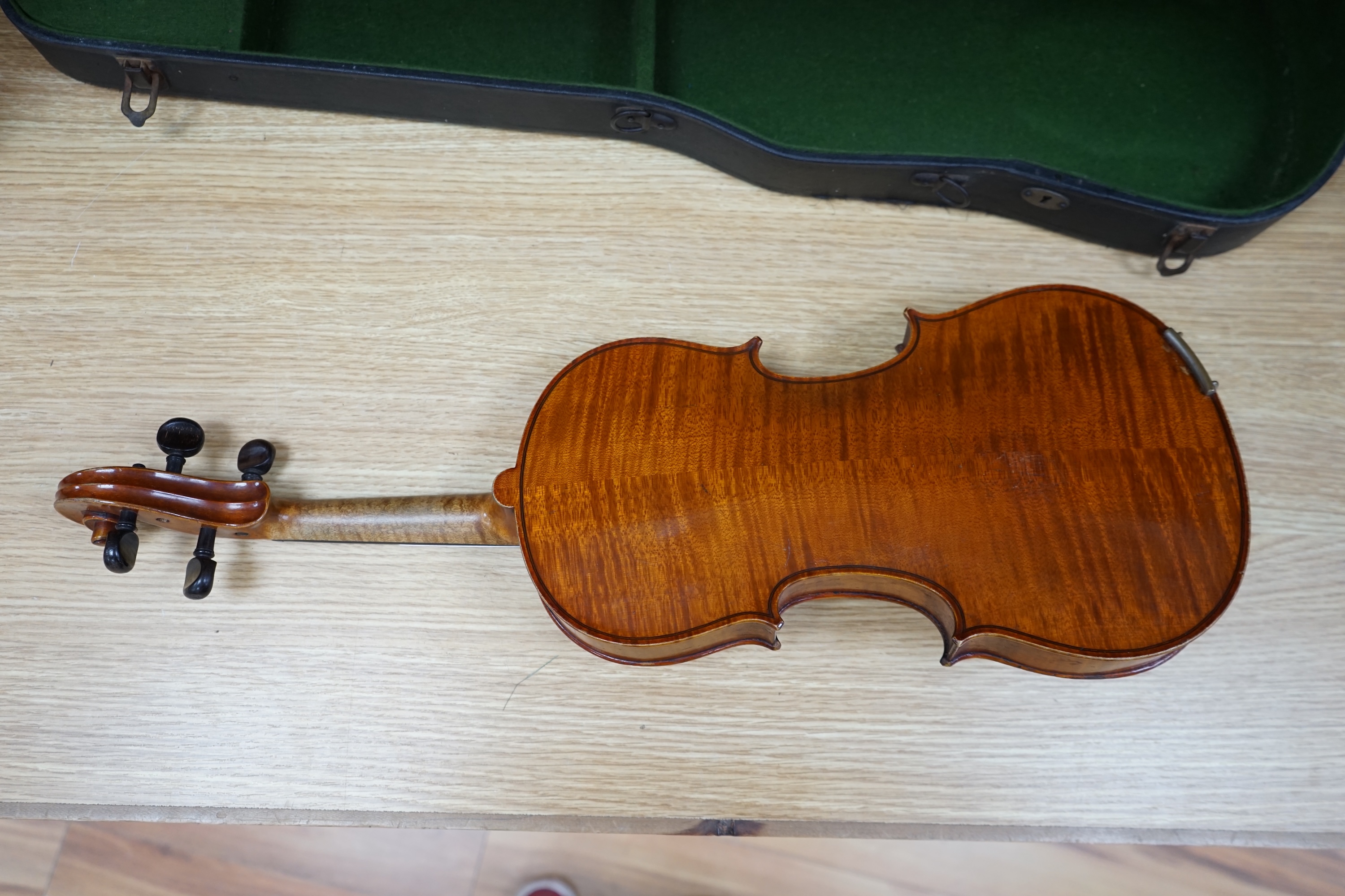 A cased early 20th century violin with bow, no label, back measures 35.5cm. Condition - fair to good